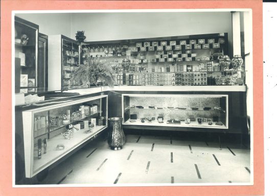 Grocery store interior with shelves, display cases, and a milk bottle on the floor.