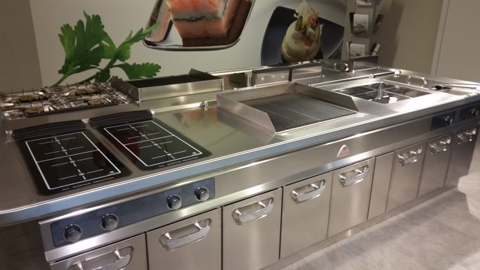 Cucina moderna in acciaio inossidabile con piani cottura e cassetti.