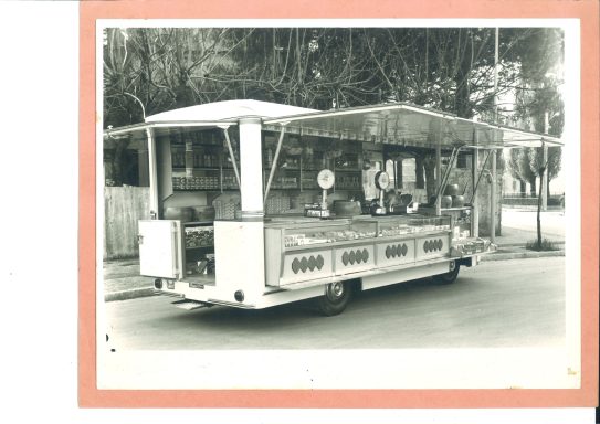 Furgone vintage con espositori di cibo e bevande su strada.