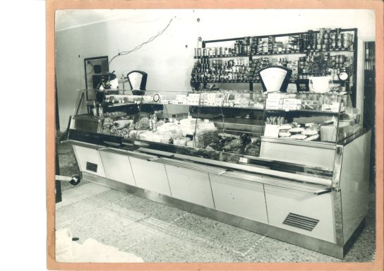 Vetrina vintage di un negozio di alimentari con prodotti in esposizione.