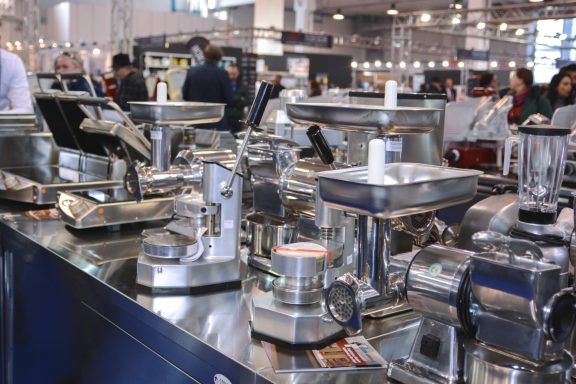 Varie macchine per la lavorazione degli alimenti esposte in una fiera.