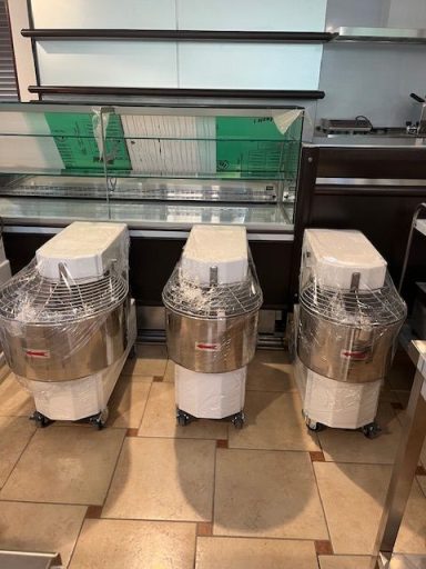 Tre macchine impastatrici in acciaio inox con contenitori trasparenti, su ruote.