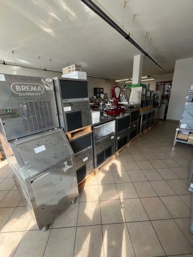 Cucina industriale con attrezzature e macchinari in un ambiente di ristorazione.